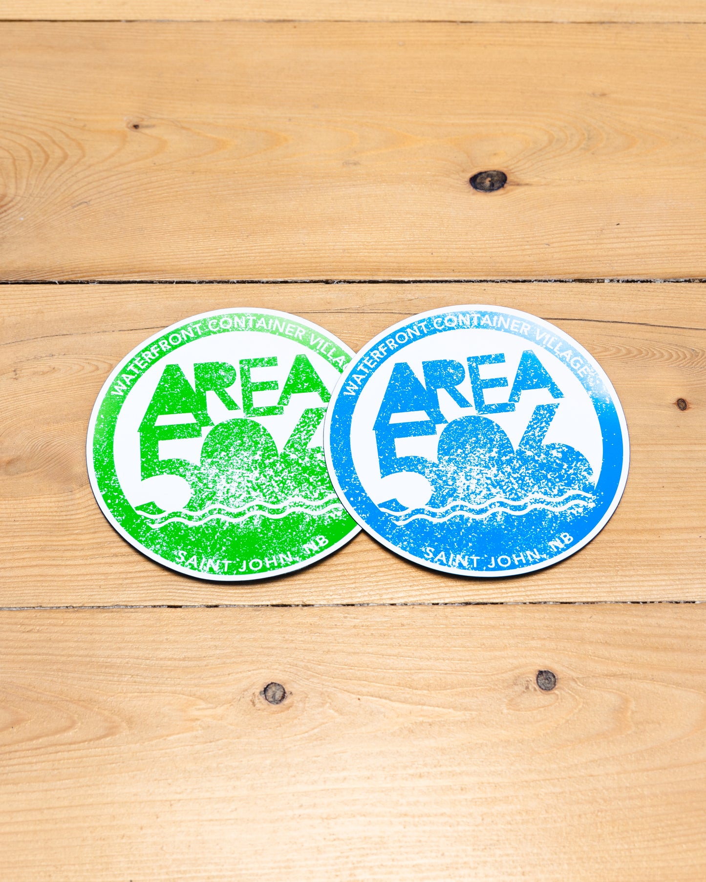 Blue or green circle magnet with AREA 506 logo, and Waterfront Container Village, Saint John, NB text.