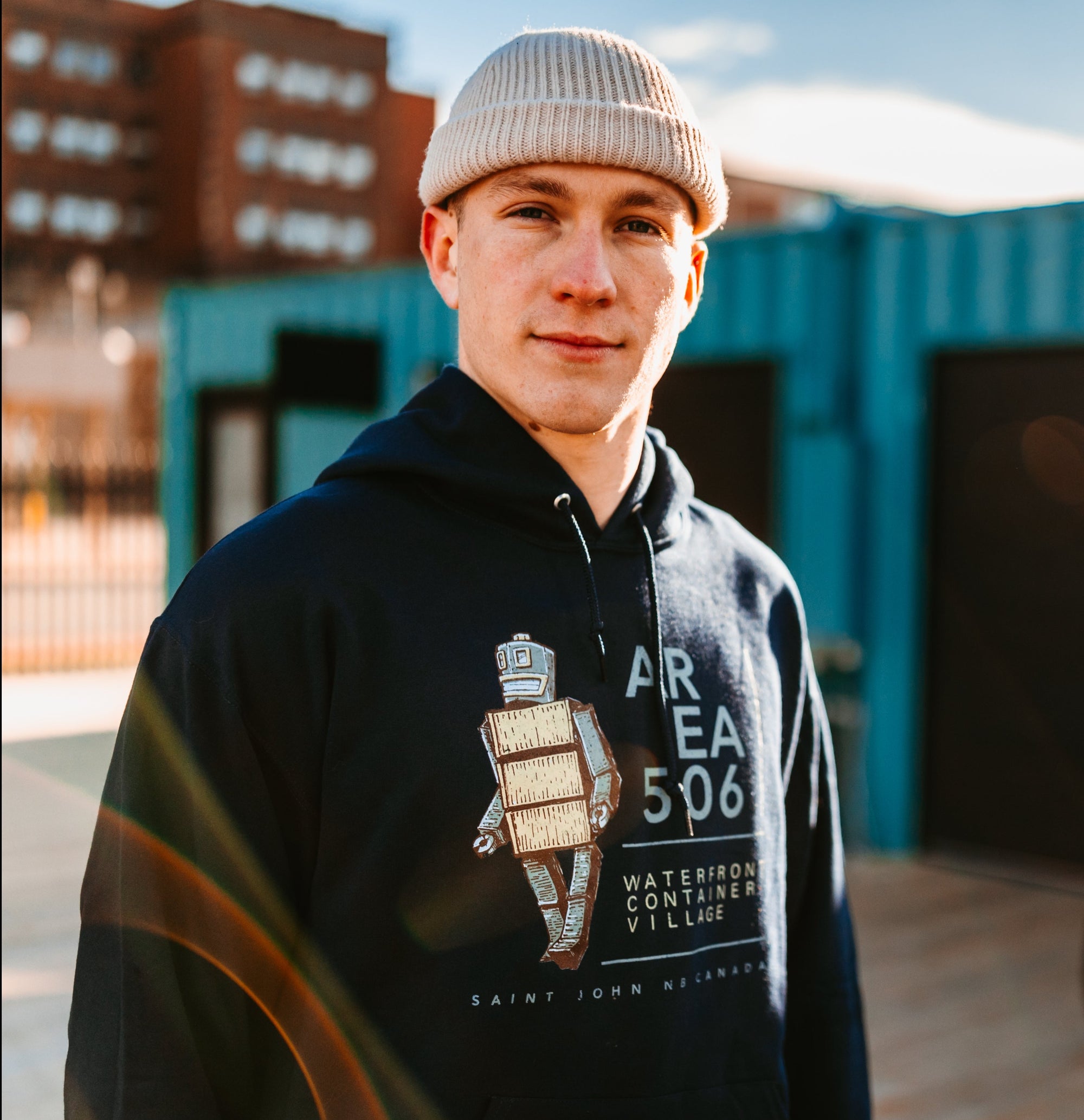 Navy blue pullover hoodie with the Robot Mascot and AREA 506 Waterfront Container Village, Saint John NB Canada text on the front.
