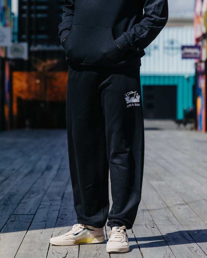 Black sweatpants with the AREA 506 galley ship logo printed on the top left leg.