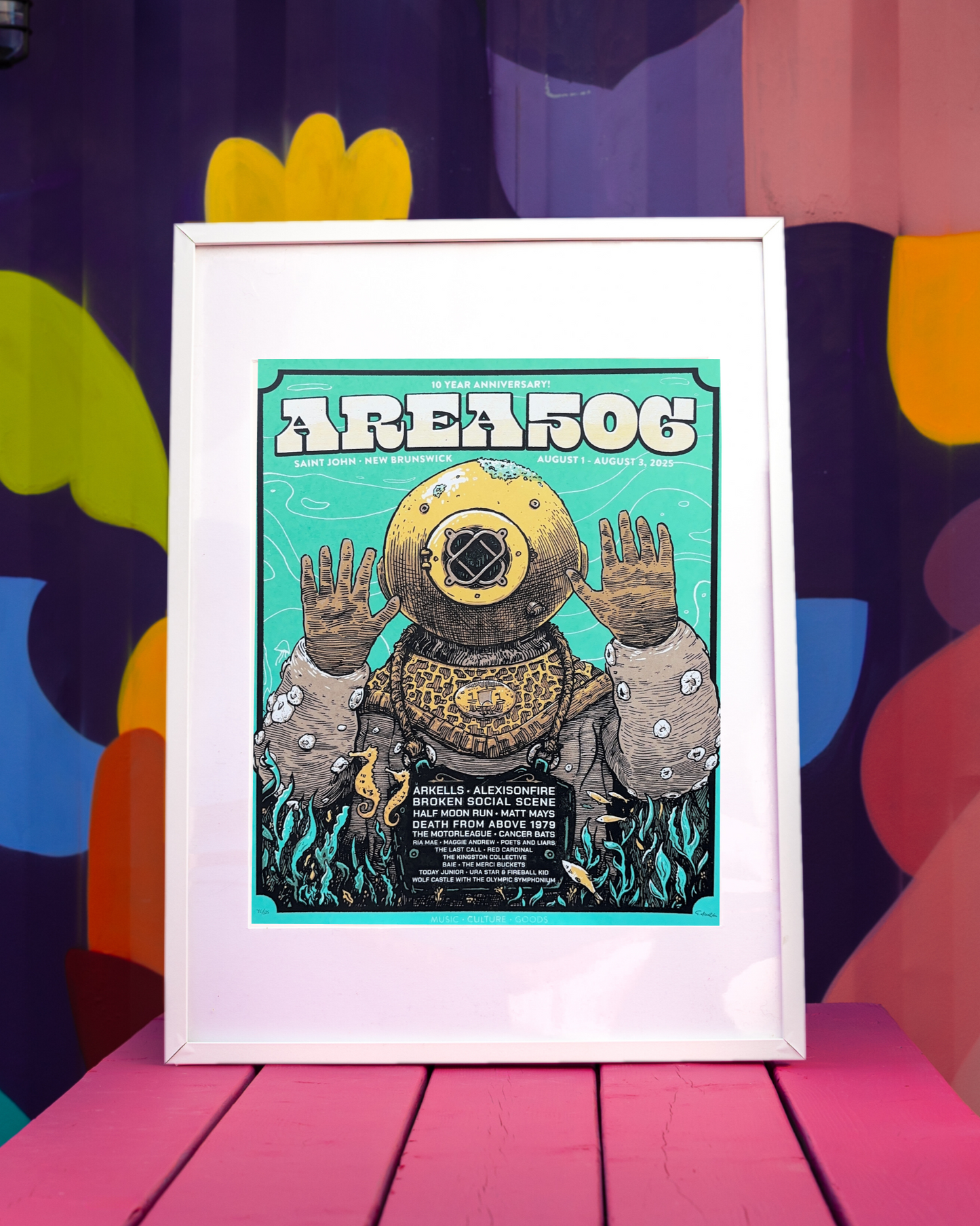 Framed poster of a diver in a vintage diving suit with 'AREA 506' text against a colorful abstract background.