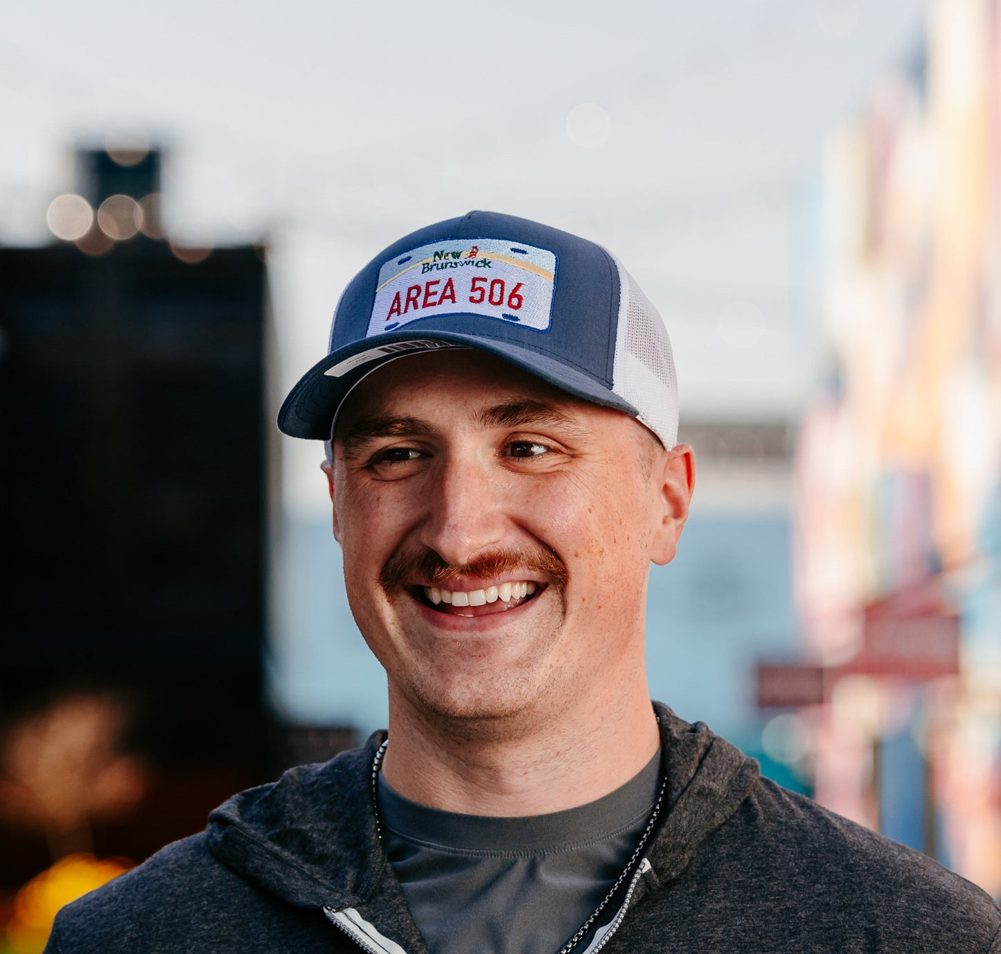 A person wearing a blue and white mesh back ball hat with 'AREA 506' embroidered on the front.