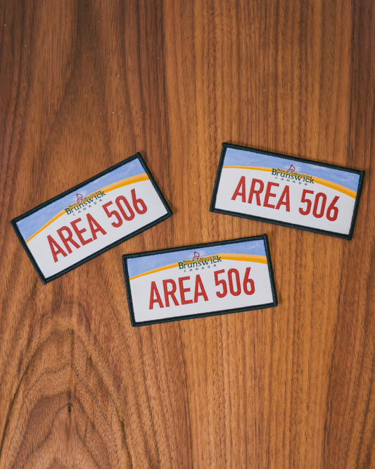 Three 'AREA 506' patches on a wooden surface