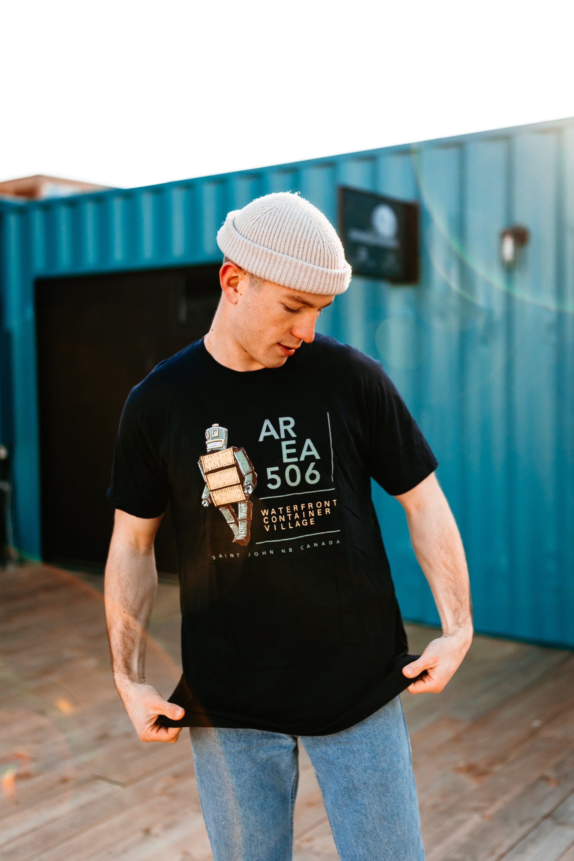 Navy blue t-shirt. Robot Mascot/AREA 506 Waterfront Container Village, Saint John NB Canada text on the front.